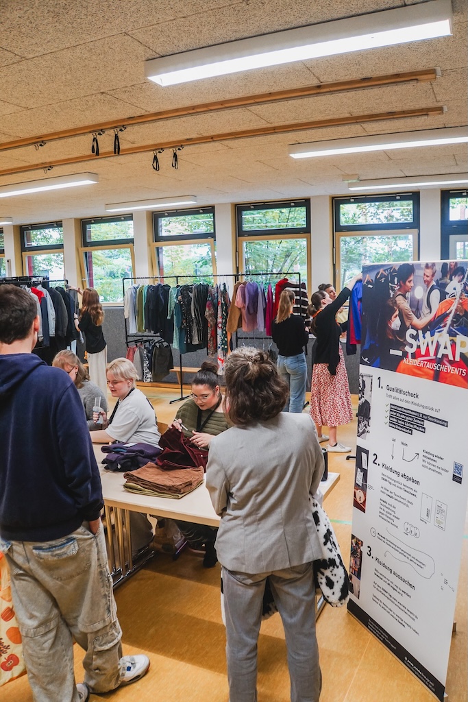 Bild vom SWAP - Kleidertauchevent mit Plakat und Kleiderauswahl